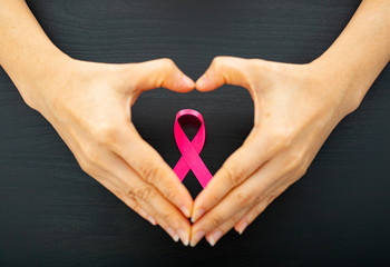 Holding pink ribbon cancer concept for show symbol.