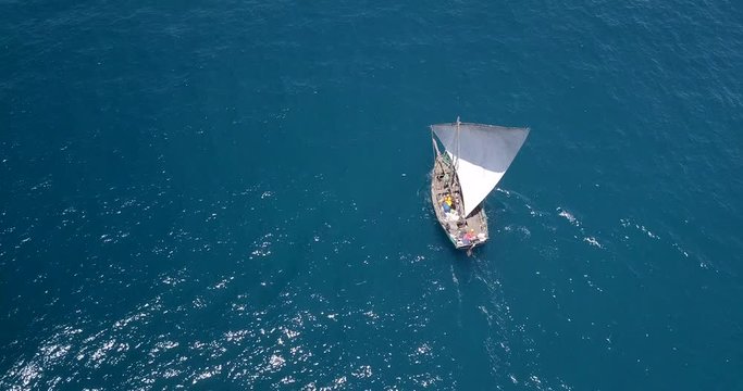 Traditional dhow sailboat sailing on the Indian ocean on the Swahili coast filmed with a drone, Tanzania.