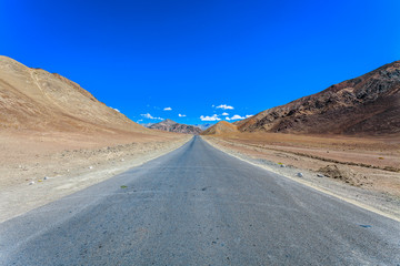 Fototapeta na wymiar Asphalt Road View with Rocky Himalayan Mountains in Leh Ladakh, India