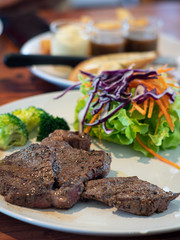 Steak made from beef and black pepper seeds On white ceramic dish in restaurant