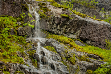 Picturesque landscape of a mountain waterfall and traditional nature of Scotland.