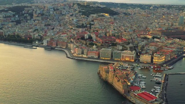 Aerial view of the colourful city of Naples and Ovo Castle at dusk, Italy