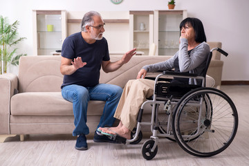 Obraz premium Old husband looking after disabled wife