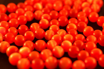 Necklace made of red cat's stone close-up on a black background blur.