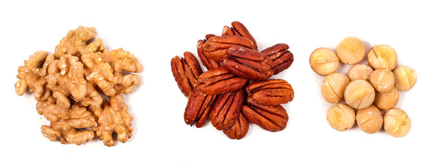 Heaps of peeled pecan nuts, walnuts and macadamia isolated on white background. Top view.