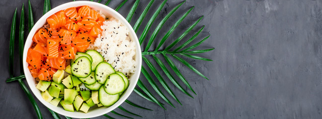Hawaiian salmon bowl with cucumbers, avocado, sesame seeds and rice. Top view, overhead, flat lay, mock up, template. Healthy food concept