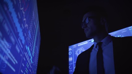The businessman working on sensor screen in the dark lab - Powered by Adobe
