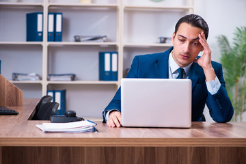Fototapeta premium Young handsome businessman working in the office