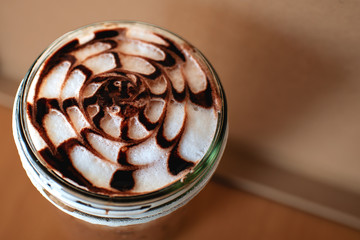Freshly brewed coffee in a cylindrical glass on the table near the top