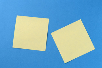 Two yellow sticker notes on a blue background with copy space. Business concept, horizontal mock-up
