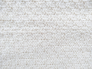 Background of wool yarn for yarn frame. White knitting yarn for handicrafts background. Knitted clothes from wool yarn.