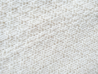 Background of wool yarn for yarn frame. White knitting yarn for handicrafts background. Knitted clothes from wool yarn.