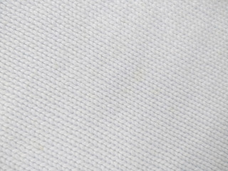 Background of wool yarn for yarn frame. White knitting yarn for handicrafts background. Knitted clothes from wool yarn.