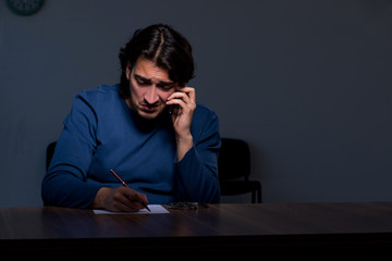 Young convict man sitting in dark room