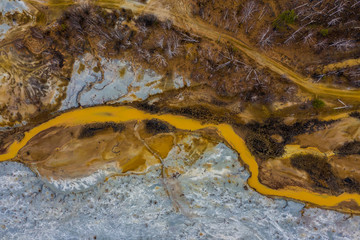 Aerial view drone flying forward over polluted river with destroyed ecosystem and copper tailing dump poisoning ground and water air emissions from industry environmental disaster in South Ural