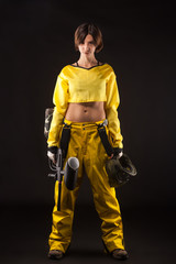 pretty woman in equipment with a paintball gun on a black background. Leisure