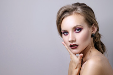 Naklejka premium beauty portrait of woman on gray background, fashion model with clean skin and beautiful lips, make up deep purple smokey eyes