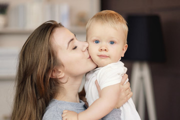 happy mother hugs son at home and kiss, feelings, relationship of mother and child,