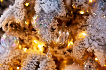 Obraz na płótnie Canvas Christmas white tree decorated snow illumination and gifts toys, background light bokeh
