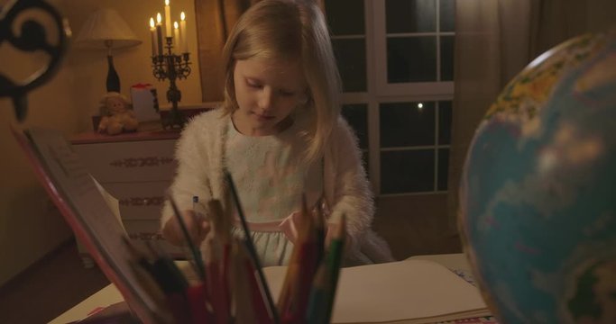 Close-up portrait of strange Caucasian girl writing down, hearing something frightening, and putting finger on lips. Clond child afraid of something abstract. Loneliness, fear, scare.