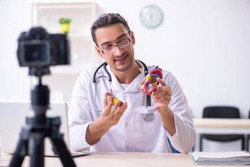 Young male doctor cardiologist recording video for his blog