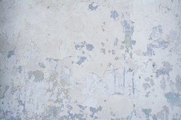 Light blue old concrete wall with partially peeling paint