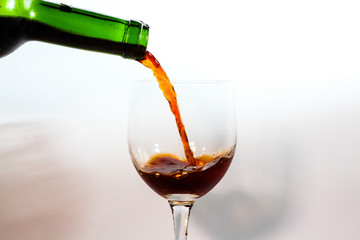 pouring red wine into glass isolated on white