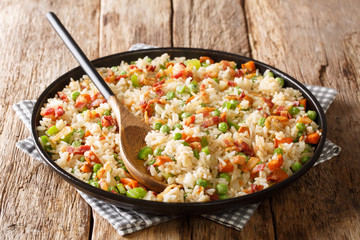 One pot of fried spicy rice with vegetables, herbs and bacon close-up in a plate. horizontal