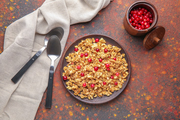 Plate with tasty granola and berries on color background