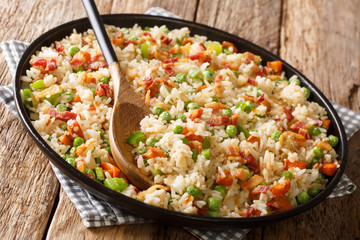 Asian rice with seasonal vegetables and bacon close-up in a plate. horizontal