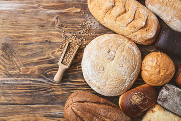 Different fresh bread on wooden table