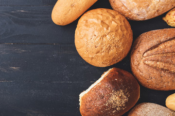 Different fresh bread on dark wooden table