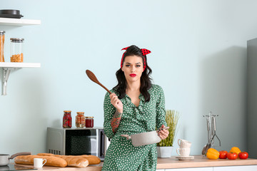 Portrait of beautiful pin-up woman cooking in kitchen