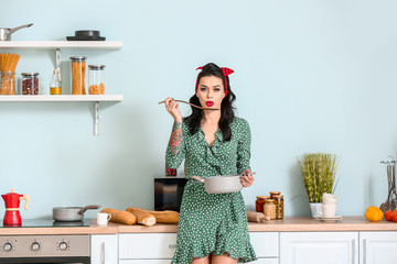 Portrait of beautiful pin-up woman cooking in kitchen