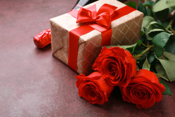 Gift for Valentine's Day, flowers and bottle of champagne on color background