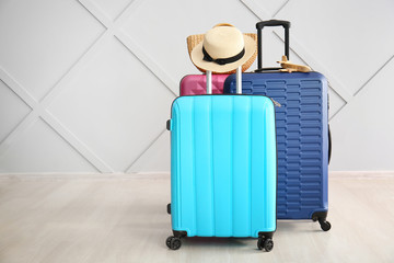 Different suitcases near light wall. Travel concept