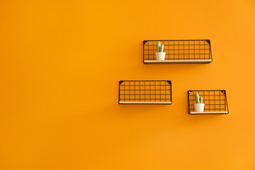 Shelves with decor hanging on color wall