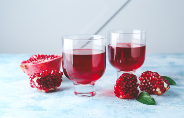 Glasses of tasty pomegranate juice on table
