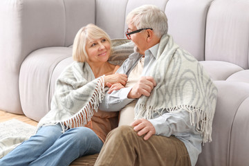 Happy mature couple resting together at home
