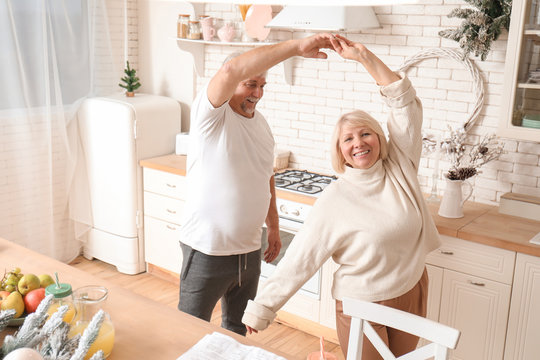 Happy Mature Couple Dancing In Kitchen