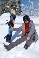 Young snowboarder riding in the mountains on a snowboard.