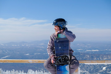 Young snowboarder riding in the mountains on a snowboard.