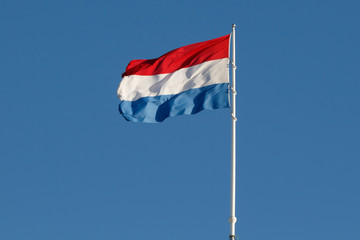 Dutch Flag of The Netherlands on blue sky background