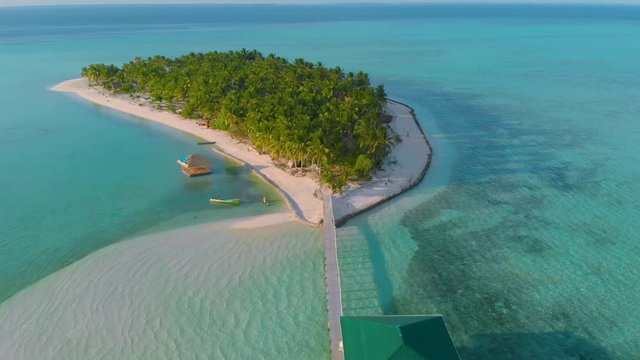 Tropical island with white beach, palm trees and endless turquoise water with coral reefs view from above. Atoll near the island travel vacation concept in Onok Island Balabac Palawan Philippines	