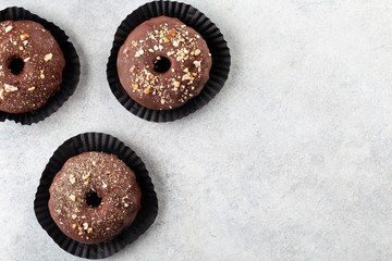 Baked chocolate doughnuts with chocolate glaze. Top view, copy space. White background.