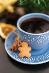 Cup of hot black coffee with christmas gingerbread cookie man, traditional holiday sweet. Winter background