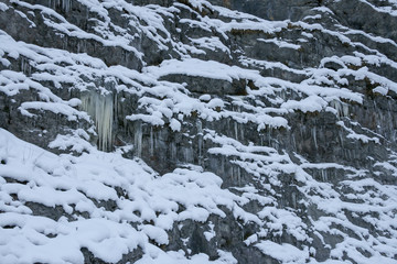 A lot of icicles have been formed due to the water rushing down the mountains and then freezing while falling down a cliff.
