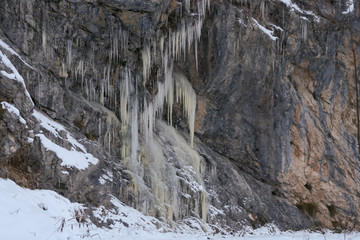 A lot of icicles have been formed due to the water rushing down the mountains and then freezing while falling down a cliff.
