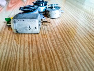 small electric motor along it's parts kept on a wooden table