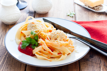 Tagliatelle pasta with meat balls and sauce on a plate, horizontal